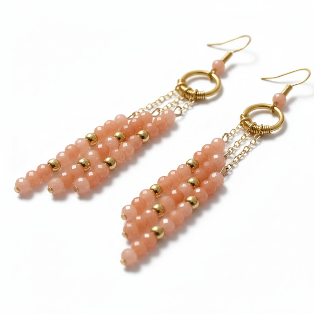 Pair of pink beaded earrings with gold accents on a white background