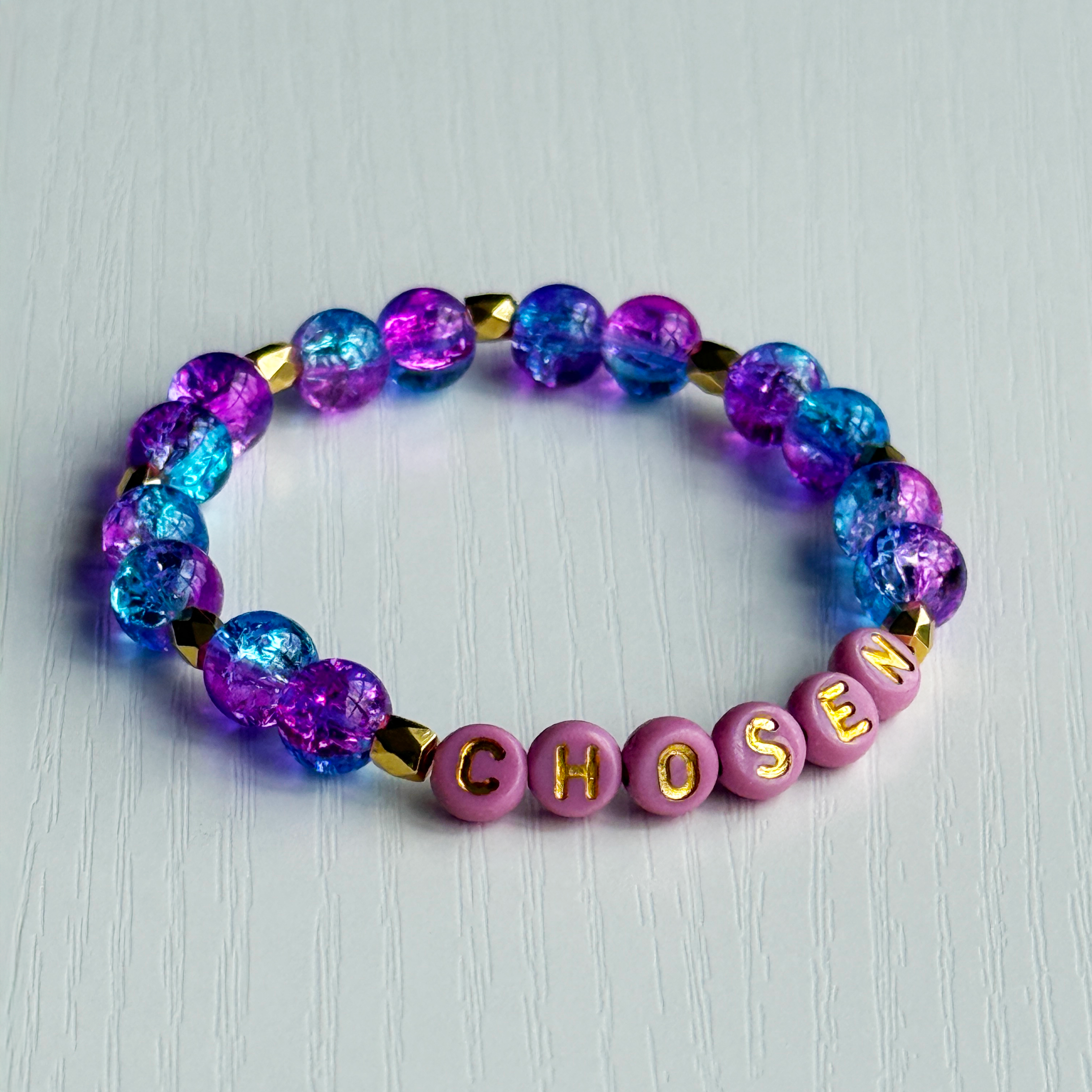Bracelet with colorful beads and 'CHosen' letters on a light gray background