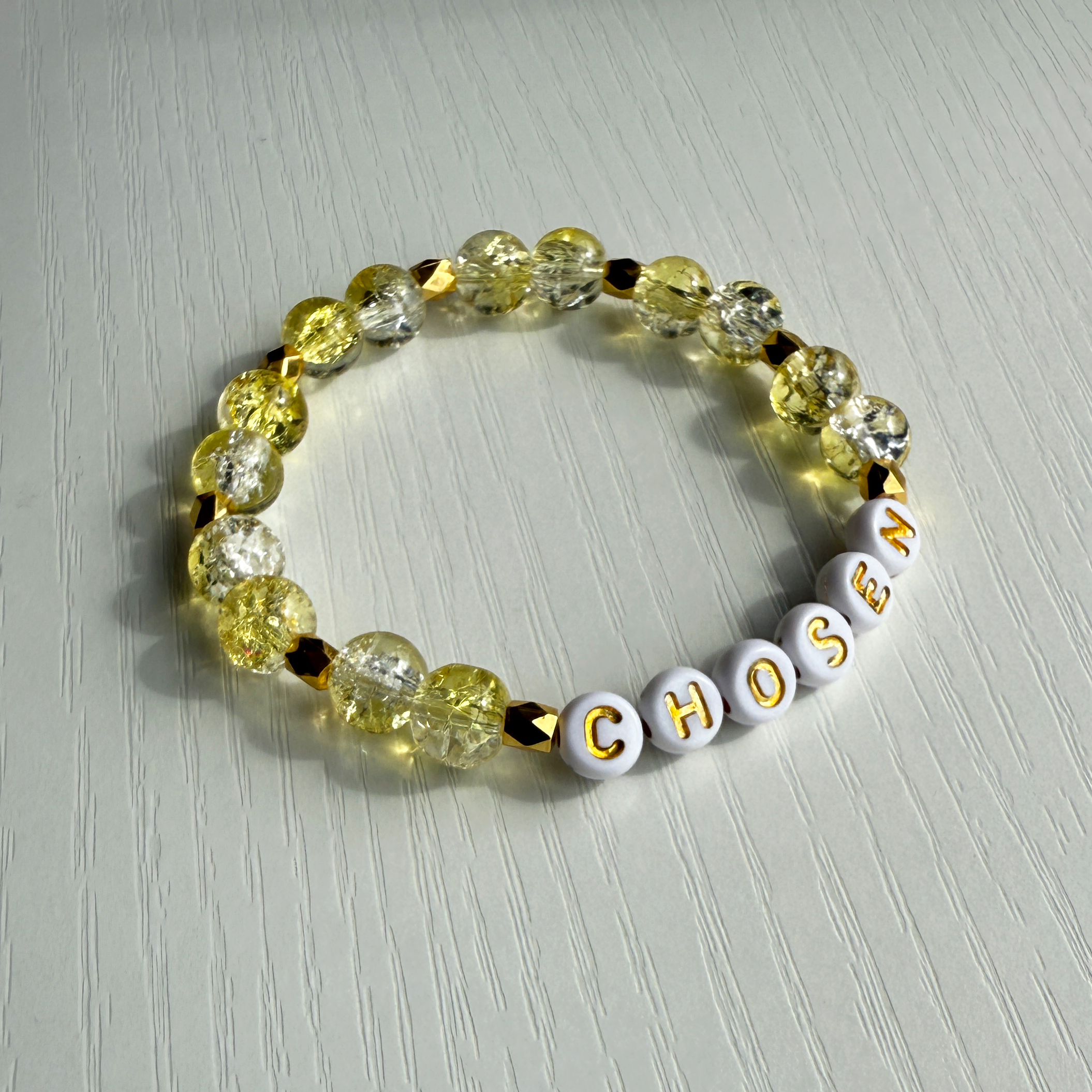 Beaded bracelet with 'CHosen' on a light gray background