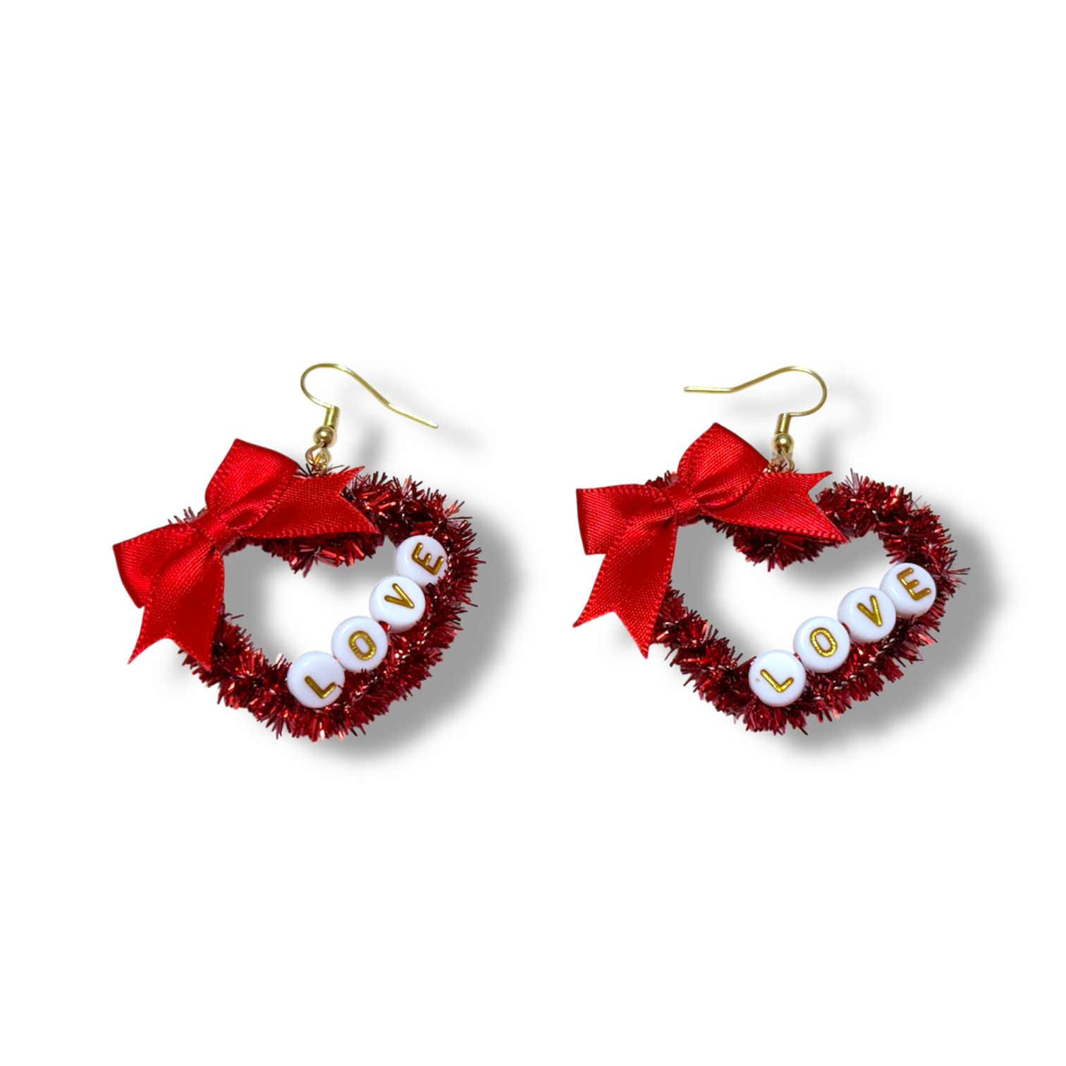 Red heart-shaped earrings with 'LOVE' letters and red bows on a white background