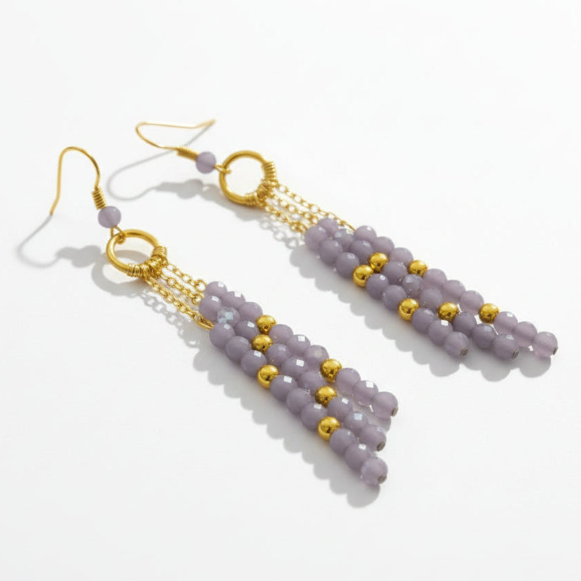 Pair of beaded earrings with gold accents on a white background