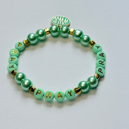 Green beaded bracelet with letter beads on a light gray background