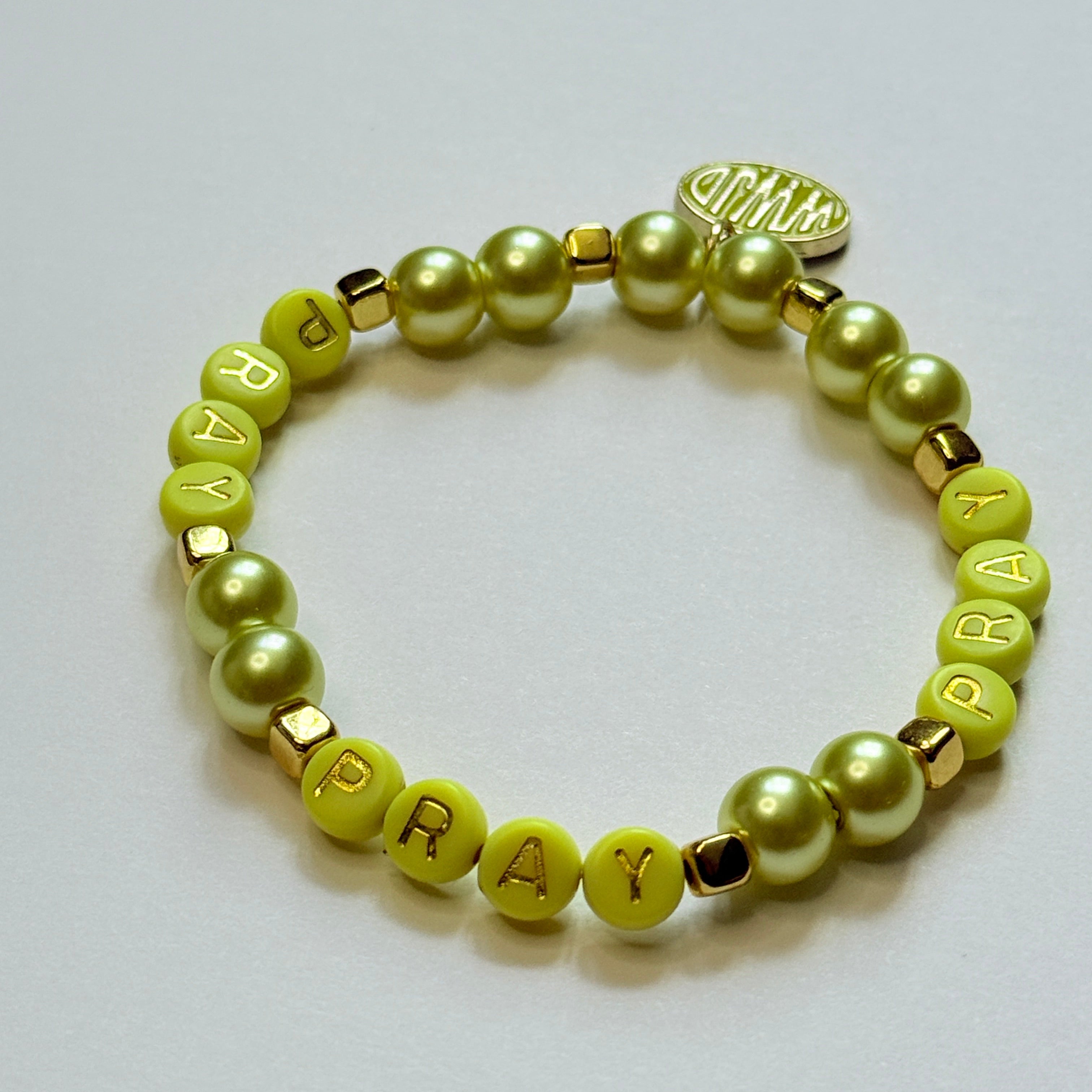 Yellow beaded bracelet with letter beads on a white background