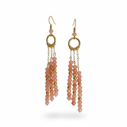 Pair of pink beaded earrings with gold accents on a white background