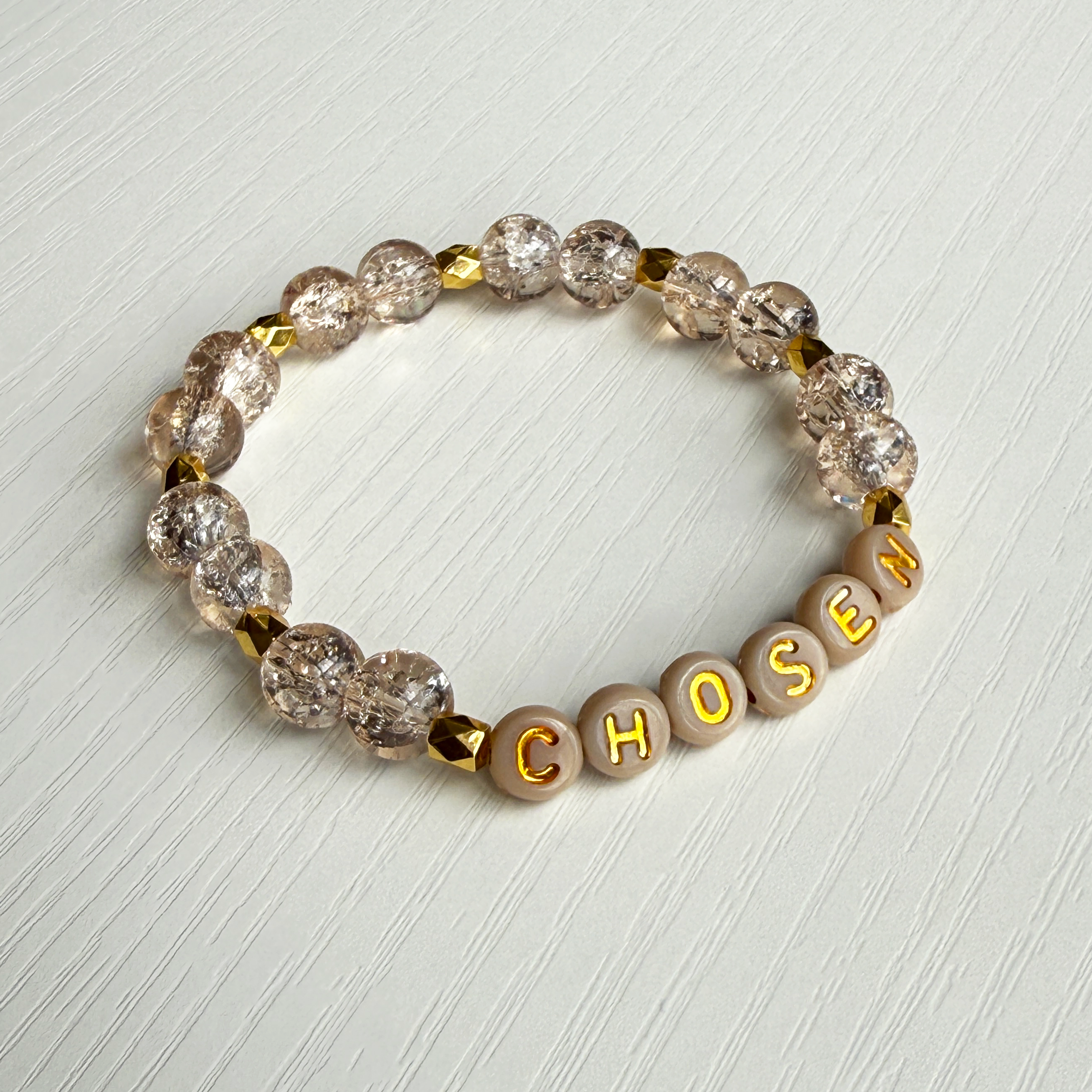 Bracelet with crystal beads and letter beads spelling 'CHOSEN' on a light background