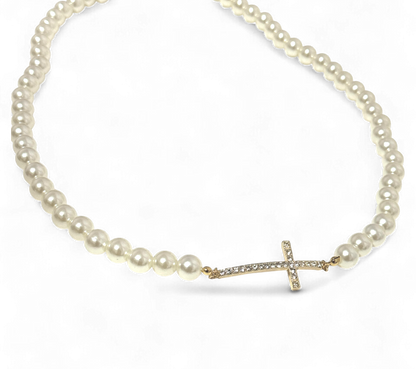 Pearl necklace with a gold cross pendant on a white background