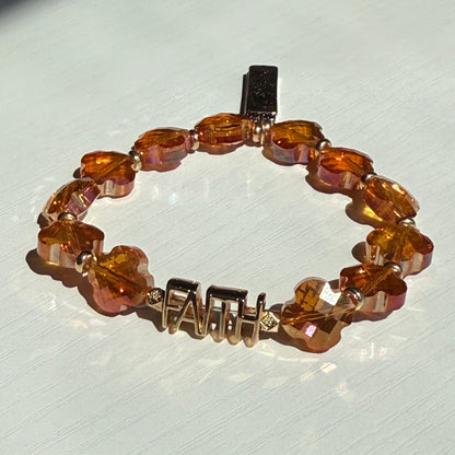 Beaded bracelet with amber-colored beads on a light gray background