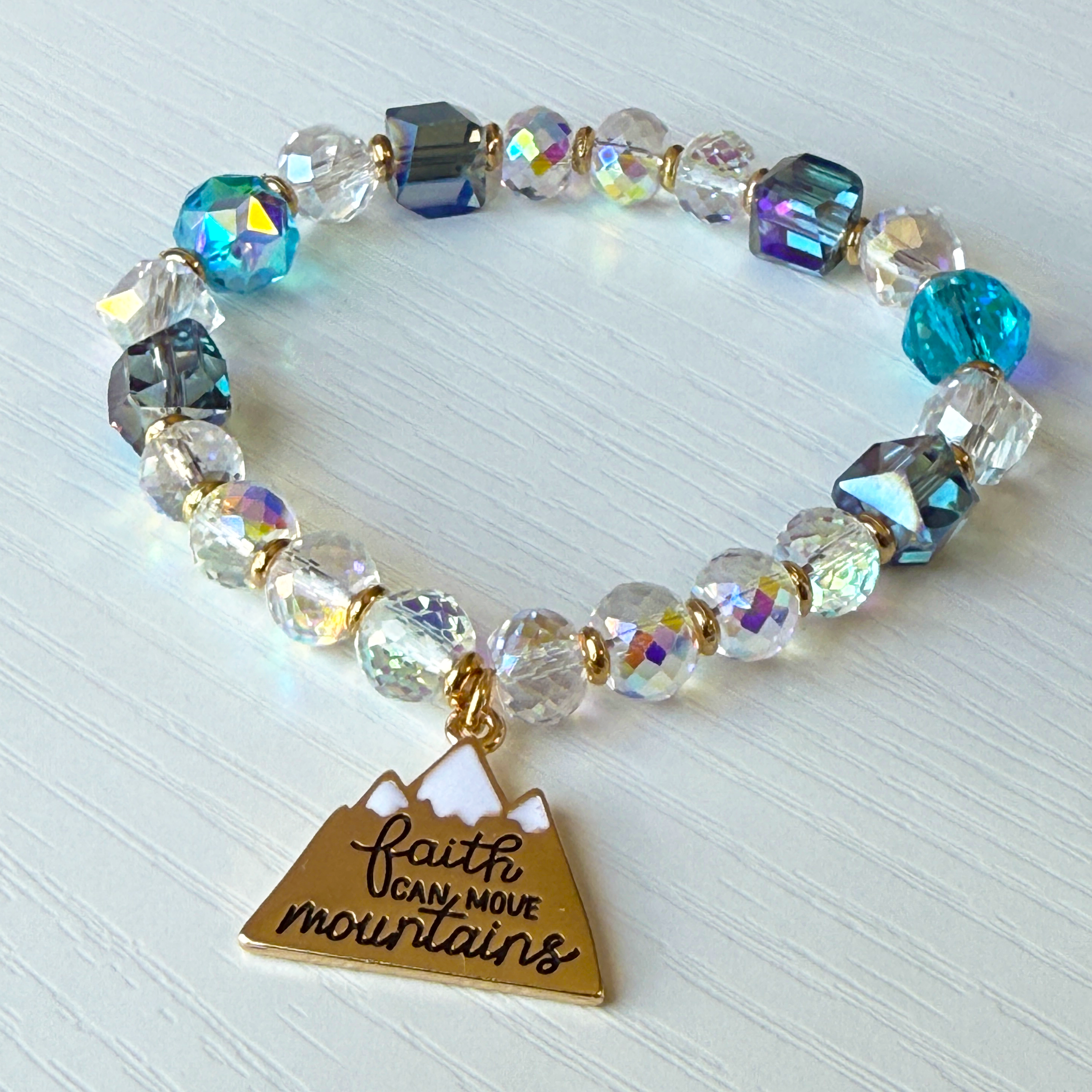 Multicolored beaded bracelet with a gold triangle charm on a light background