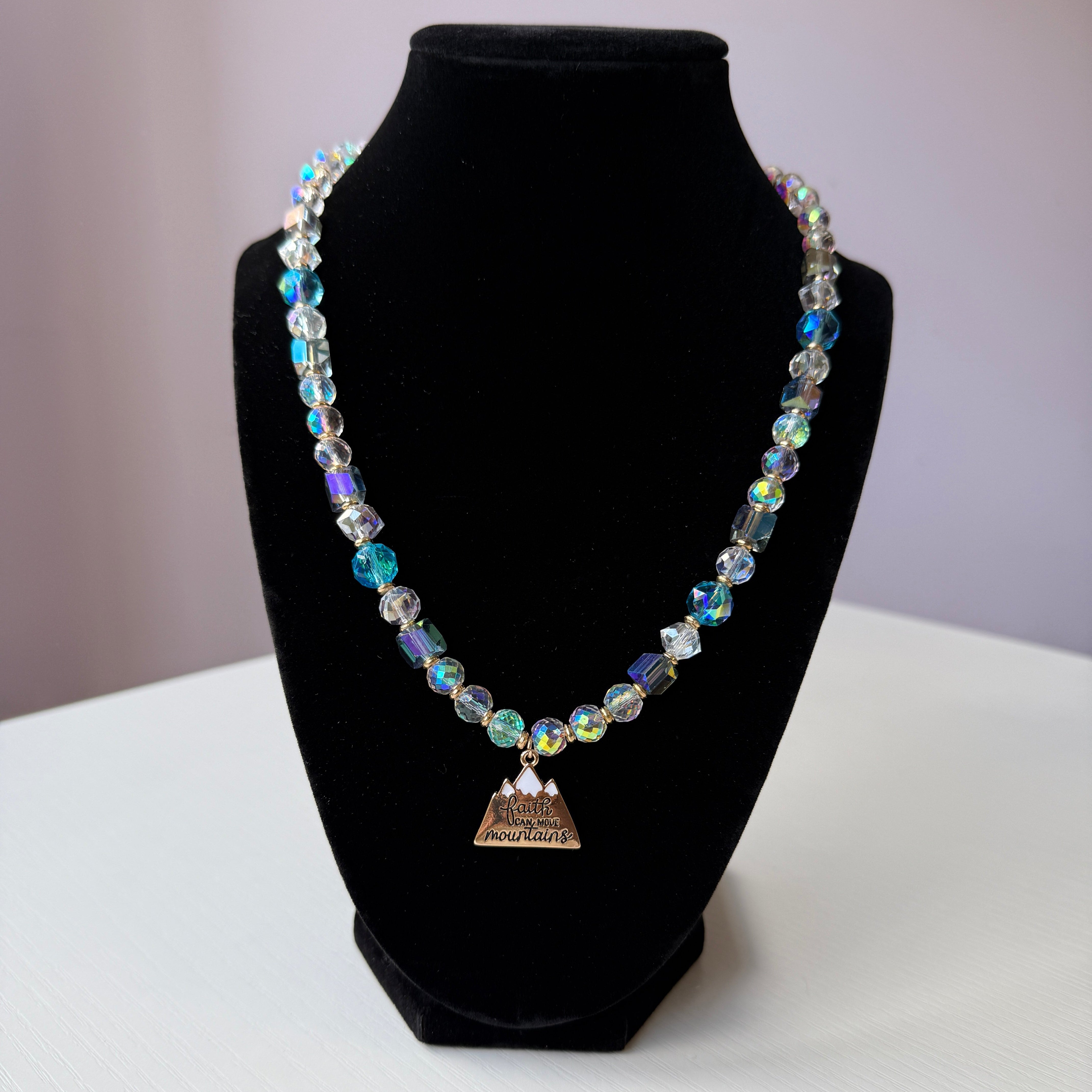 Necklace with multicolored beads on a black stand against a white background