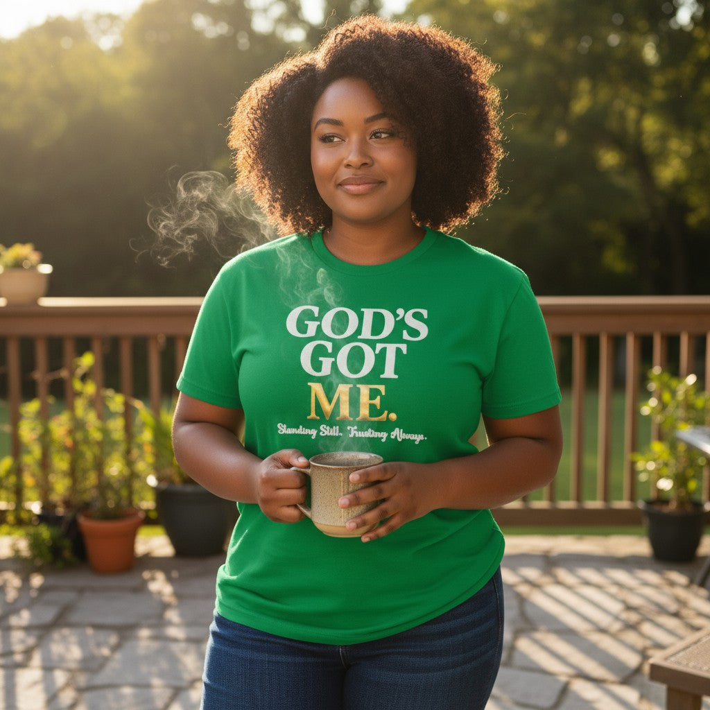Woman wearing a green t-shirt with 'GOD'S GOTME' text, holding a mug outdoors.