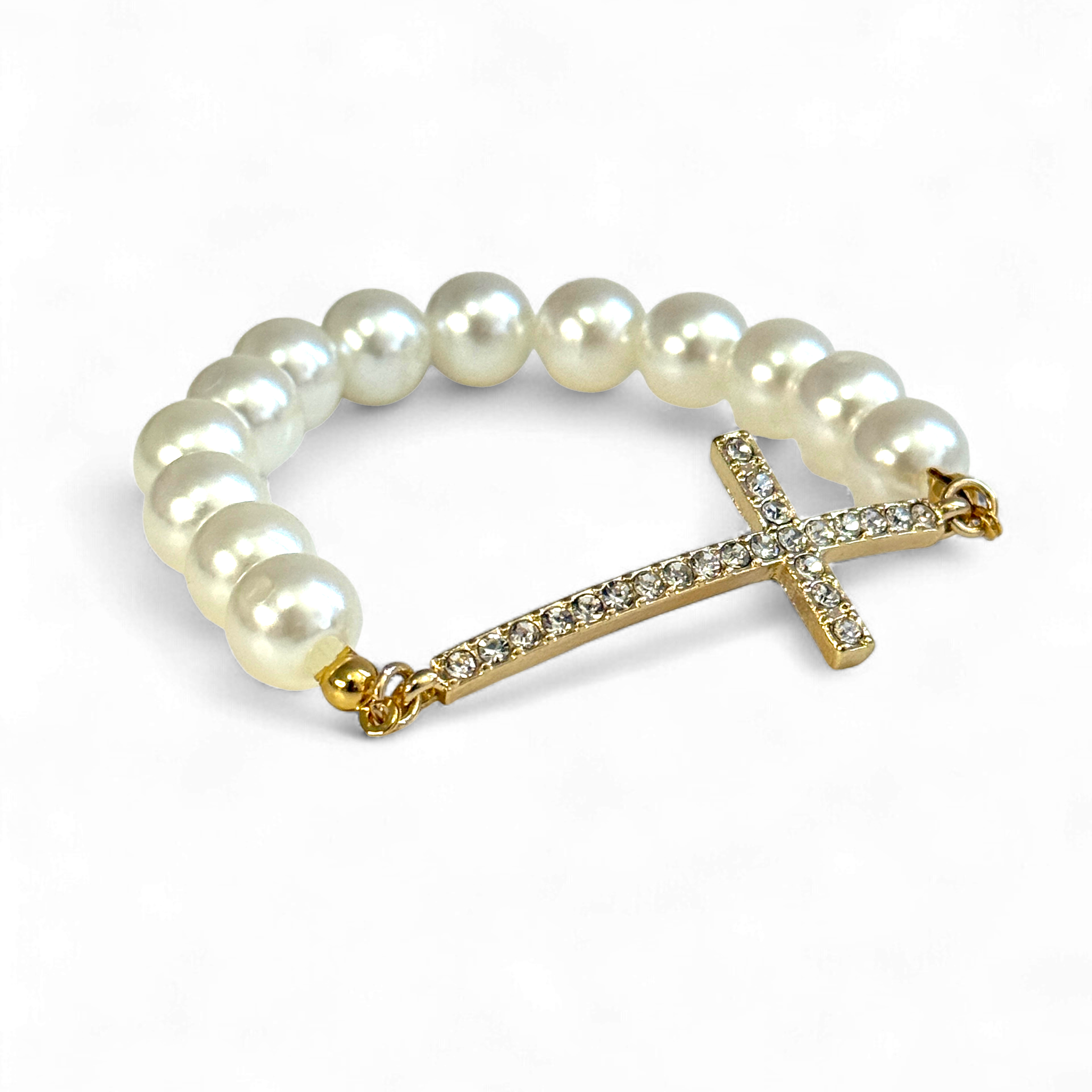 Pearl bracelet with a gold cross charm on a white background