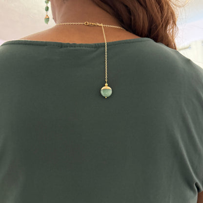Person wearing a necklace with a pendant, viewed from behind