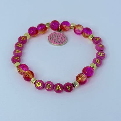 Pink beaded bracelet with 'PRAY' letters on a light purple background