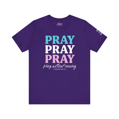 Purple t-shirt with 'PRAY PRAY PRAY' text in blue, white, and pink on a white background