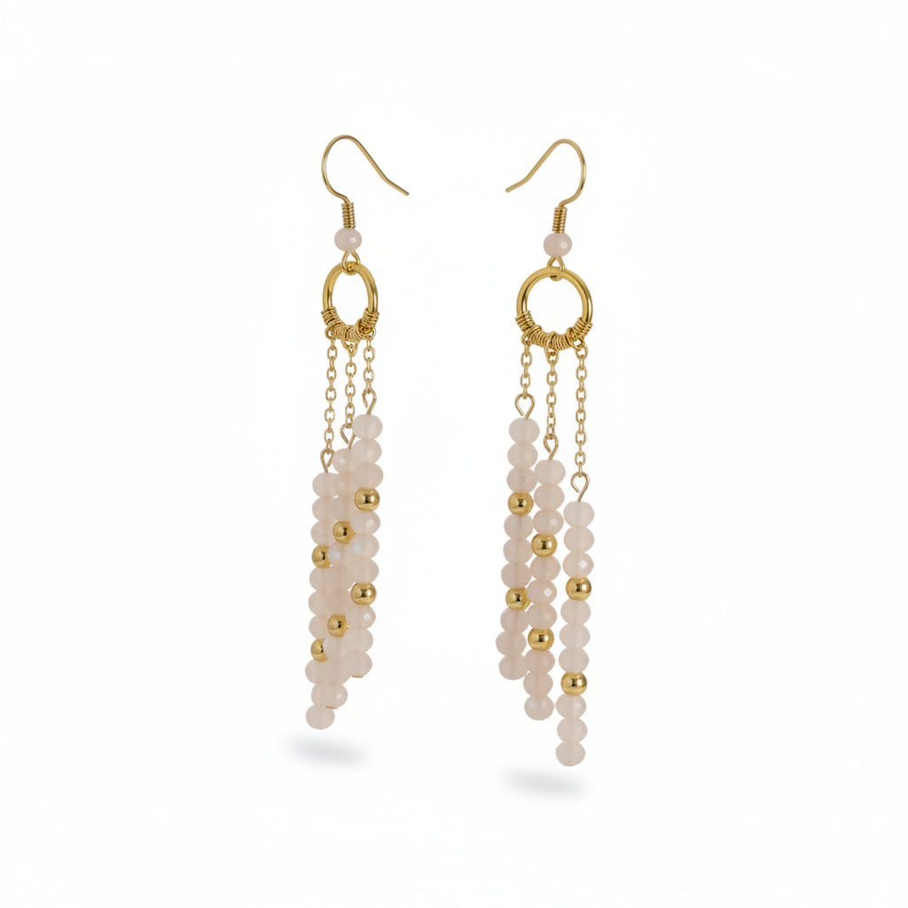 Pair of gold and white beaded earrings on a white background