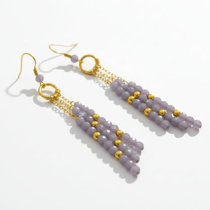 Pair of beaded earrings with gold accents on a white background