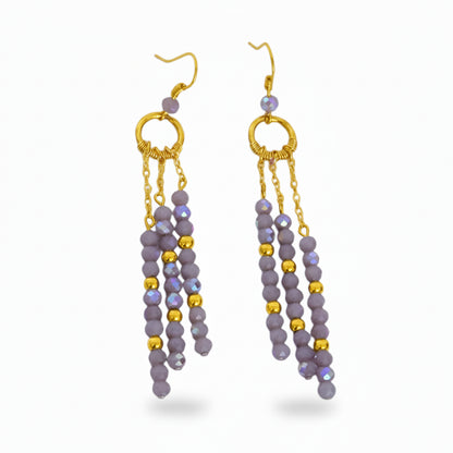 Pair of gold and purple beaded earrings on a white background